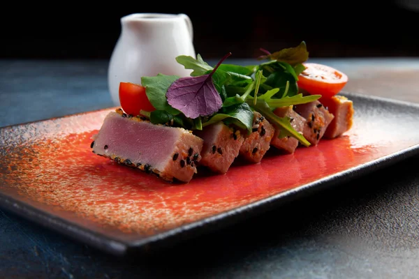 Taze domatesli kızarmış ton balığı, susam tohumu ve roka salatası. Seçici odak