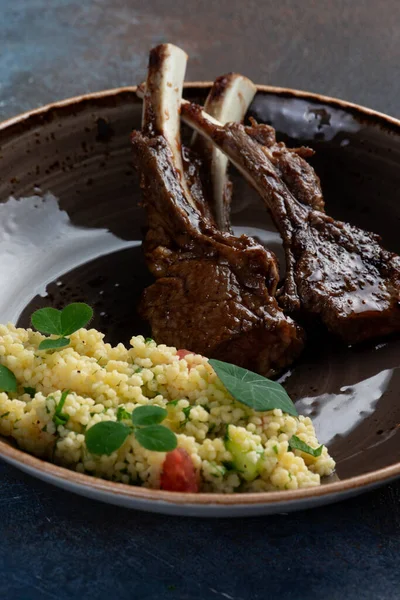 Karanlık bir arka planda, tabakta kuzu askısı. Seçici odak