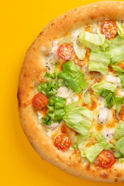 Domatesli pizza ve sarı arka planda salata. Seçici odak
