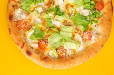 Domatesli pizza ve sarı arka planda salata. Seçici odak