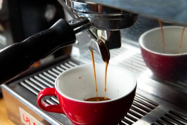 Kahve makinesi fincana kahve doldurur. Yakın plan. Seçici odak