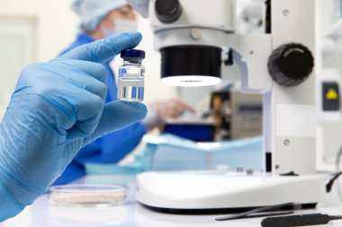 Bir bilim adamı ya da doktor elinde aşı tutuyor. seçici odak.