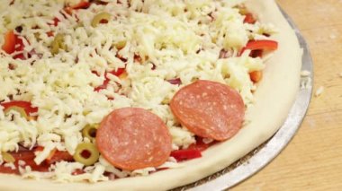 Pizzanın üzerine sosis dilimleri yayılır. Seçici odak.