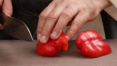 Profesyonel bir şef tatlı biberleri dilimler. Seçici odak.