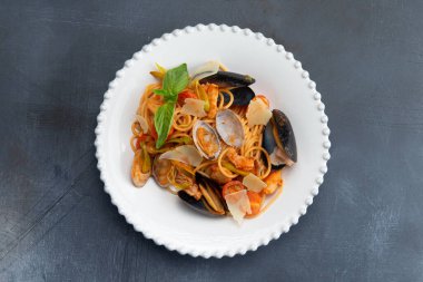 Gri arka planda deniz ürünleri tabağında makarna. Seçici odak.