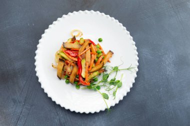 Tabakta kızarmış sebze. Gri bir arka planda. Seçici odak.