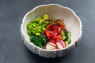 Bir tabakta somon, fasulye ve turpla dürt. Gri bir arka planda. Seçici odak.