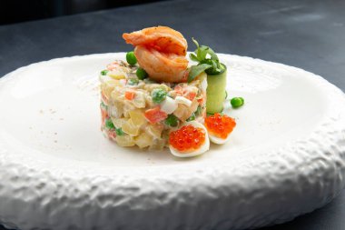 Yumurtalı, bezelyeli, patatesli ve mayonezli geleneksel Rus salatası. Gri bir arka planda. Seçici odak.