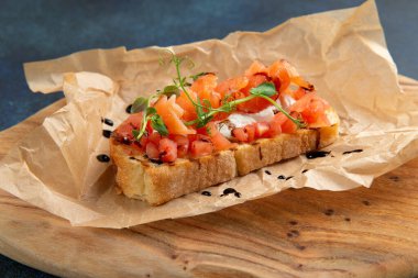 Somon ve domatesli bruschetta. Karanlık bir arka plana karşı. Seçici odak.