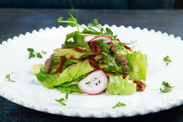 Salade Met Vlees Zongedroogde Tomaten Radijs Een Bord Tegen Een — Stockfoto