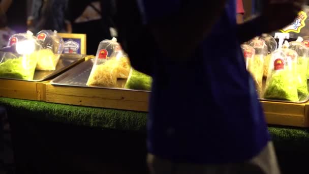 Mercado nocturno asiático. Jefe cocinando dulces exóticos como caramelos y chicle. 4K — Vídeo de stock