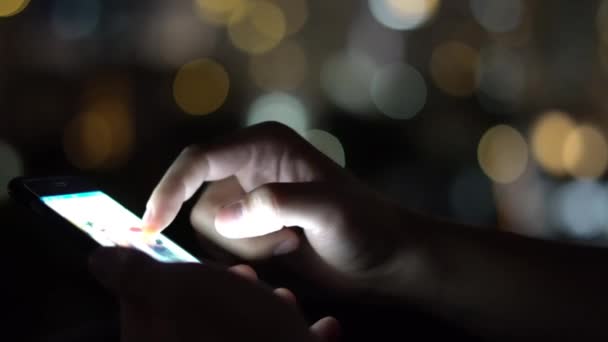 Człowiek, przeglądania społecznej netto przy użyciu telefonu komórkowego w czasie wieczoru na dachu w wielkim mieście. Szczelnie-do góry. 4k — Wideo stockowe
