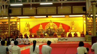 Buda günde Budist tapınağı. İnsanlar mumlar, çiçekler ve tütsü sopa getir. WAT Nakha Ram, Phuket, Tayland. 4k