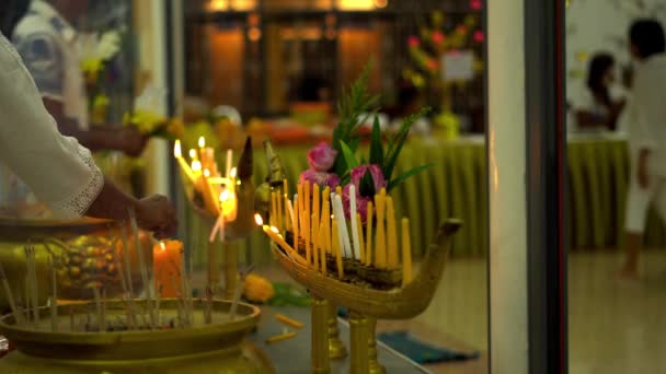 Giorno di Budda in tempio buddista. La gente mette candele, fiori e bastoncini di incenso. Wat Nakha Ram, Phuket, Thailandia. 4K — Video Stock