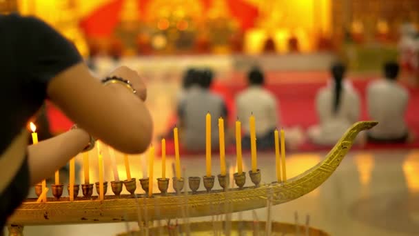 Dia de Buda no templo budista. As pessoas colocam velas, flores e paus de incenso. Wat Nakha Ram, Phuket, Tailândia. 4K — Vídeo de Stock