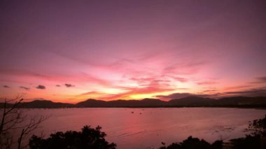 Deniz, dağlar arka planda, renkli gökyüzü günbatımı. Gemiler, okyanus. Phuket. Tayland. Asya. 4k