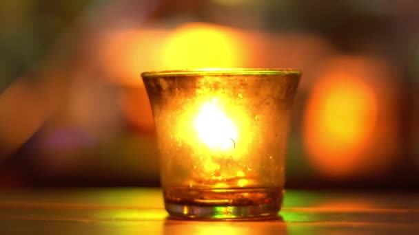 Candle in a glass stay on wooden table in blues music bar. Blurred backround. Bokeh. Colored illumination. 4K — Stock Video