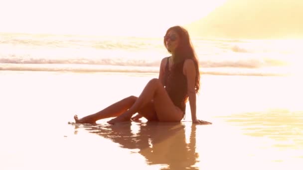 Bella donna sdraiata sulla sabbia riflessa in esso. 4K — Video Stock