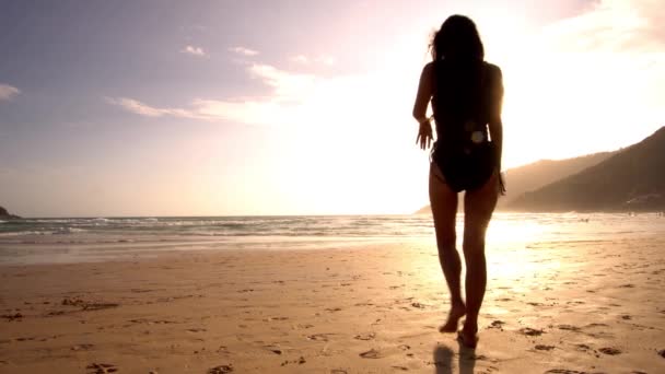 Plage. Femme marchant dans la mer sur le sable. Elle se retourne et sourit. 4K — Video