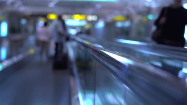 Personas que se desplazan por escaleras mecánicas planas en una terminal del aeropuerto o estación de tren. Movimiento lento — Vídeo de stock