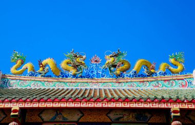 Tapınağın çatısında altın ejderha heykeli, Çin tapınağının çatısında Asya sanatı olarak ejderha heykeli, mavi gökyüzü arka planı.