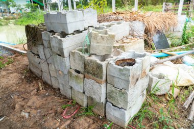  Eski gri beton blokları düzgün bir şekilde yığılmış, ince tuğlalar, bir ev inşa etmek için malzemeler.