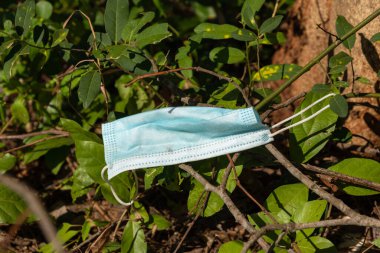 Yere dökülen kullanılmış bir tıbbi maske. Coronavirus, Covid-19 ve Çevre Kirliliği Konsepti.