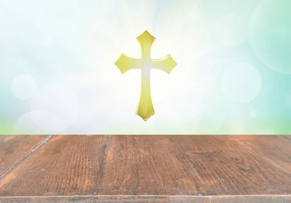 Houten tafelblad op bokeh met het Heilig Kruis — Stockfoto