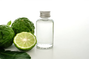 Beyaz arka planda Bergamot yağı ve taze bergamot..