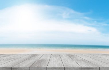 Plaj, gökyüzü ve yazın doğal ışığıyla dolu boş ahşap masanın tepesinde. Ticaret fuarları, reklamlar ve promosyonlar için..