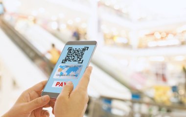 Süpermarketteki mal ve hizmetlerin parasını hızlı ve kolay ödemek için akıllı bir telefonun QR kodunu tara. Dijital teknoloji kavramı.
