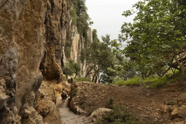 Bir grup insan Faro del Caballo yolunda yürüyor. Doğanın merdivenleri.