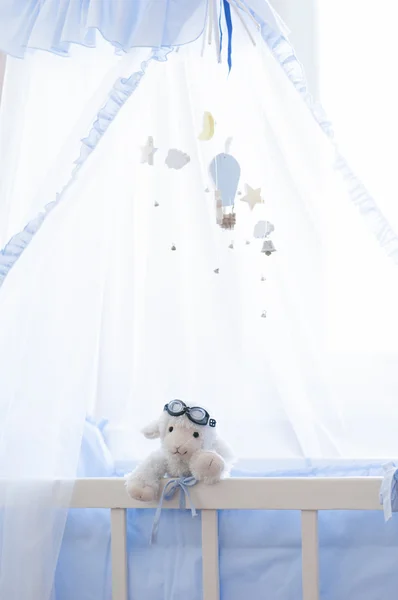 Babywieg met hangende houten speelgoed. — Stockfoto