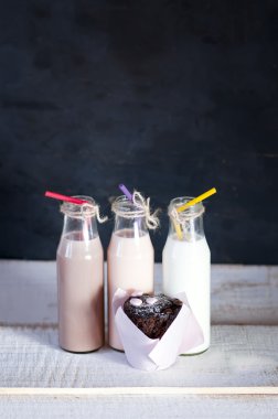 Üç retro şişe süt kokteyl ve çikolatalı kek ile. 