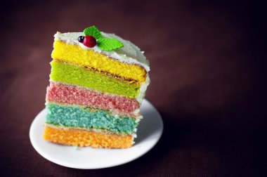 Bir uğur böceği üstüne gökkuşağı kek süslenmiş. 