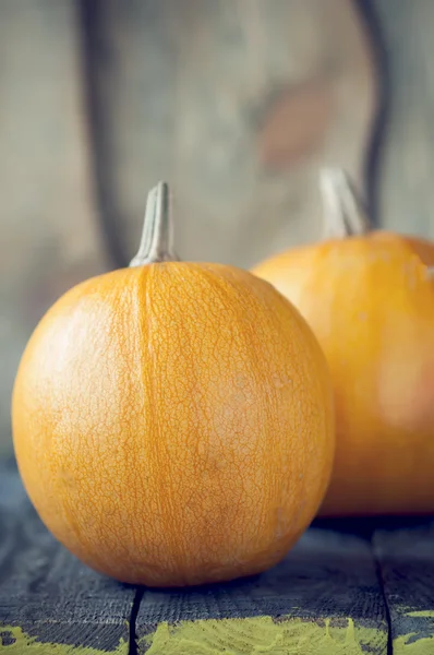 Pumpkins lie on wooden board — Stock Photo, Image