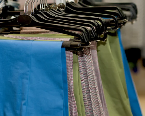 Group of colored pants on hangers — Stock Photo, Image