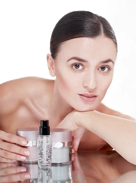 Kvinna med en välskött hud nära krämer kosmetika — Stockfoto