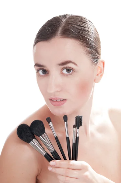 Woman with healthy complexion is holding near the face make-up brush set — Stock Photo, Image