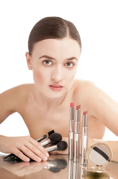 Pretty  woman near the glamour red lipsticks and make-up brushes — Stock Photo, Image