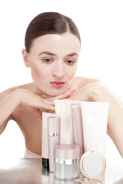 Young woman with  a well-groomed skin near the creams cosmetics — Stock Photo, Image