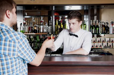 bartender gives the man ordered a cocktail clipart