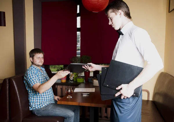 Homem faz uma ordem para o garçom em um restaurante . — Fotografia de Stock