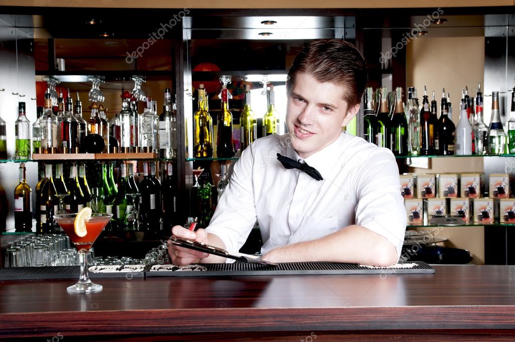 Young smiling bartender taking an order.