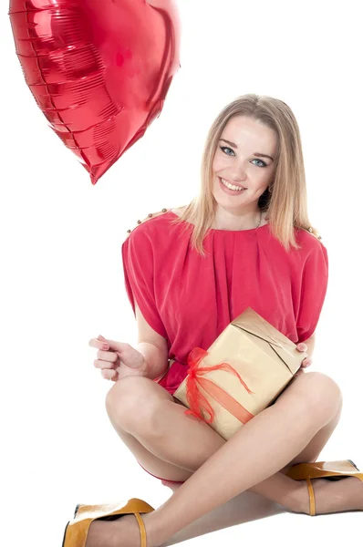 Beautiful woman with red heart balloon and a gift box sitting — Stock Photo, Image