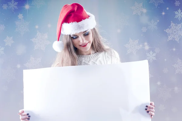 Happy young christmas girl holding a blank paper sign — Stock Photo, Image