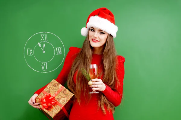 Young happy woman dressed in red dress and santa hat — Stock Photo, Image