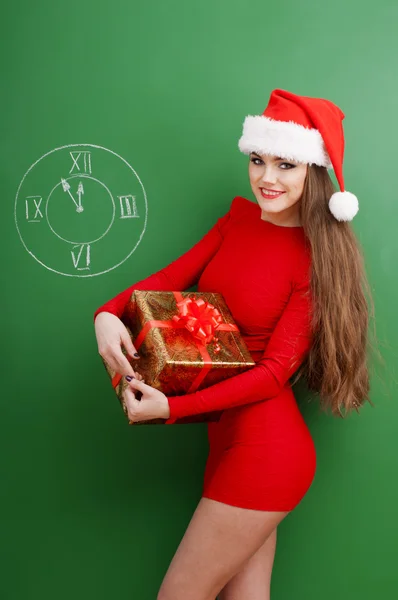 Jonge gelukkig vrouw gekleed in rode jurk en santa hoed — Stockfoto