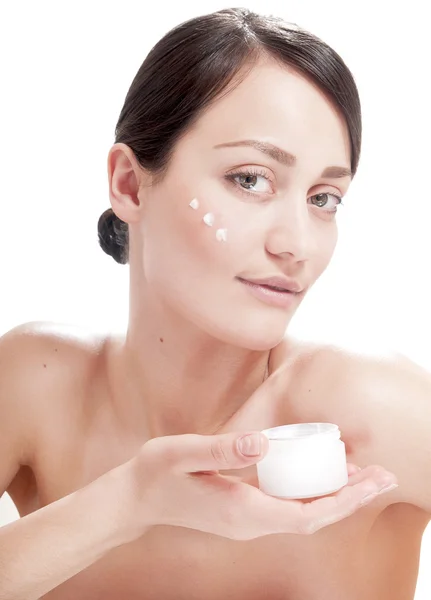 Beautiful woman applying cosmetic cream treatment on her face — Stock Photo, Image