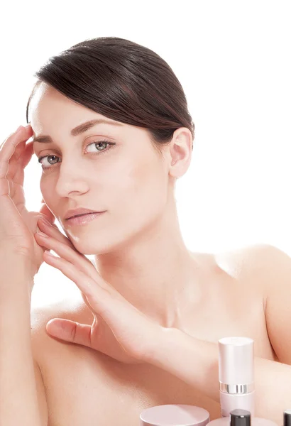 Kvinna med välvårdad hud nära kosmetika — Stockfoto